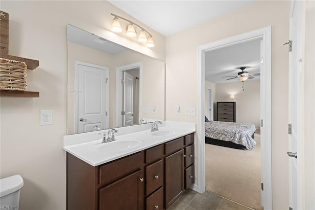 bathroom with double vanity, a sink, toilet, and connected bathroom