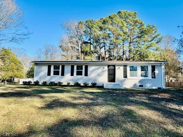 ranch-style house featuring a front yard and fence