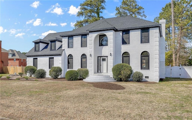 view of front of house featuring brick siding, fence, crawl space, a gate, and a front yard