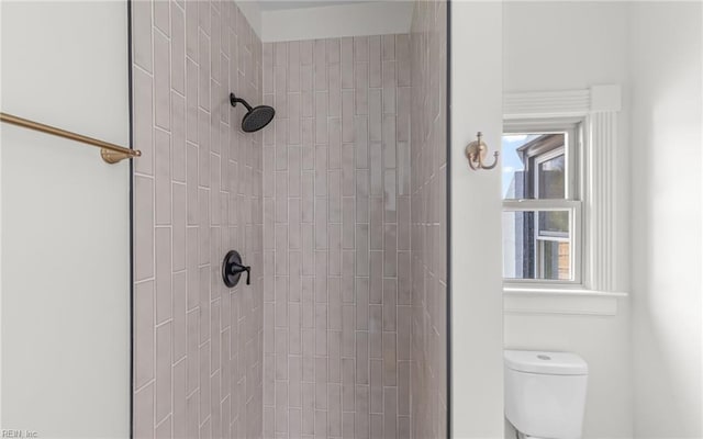 full bathroom with tiled shower and toilet