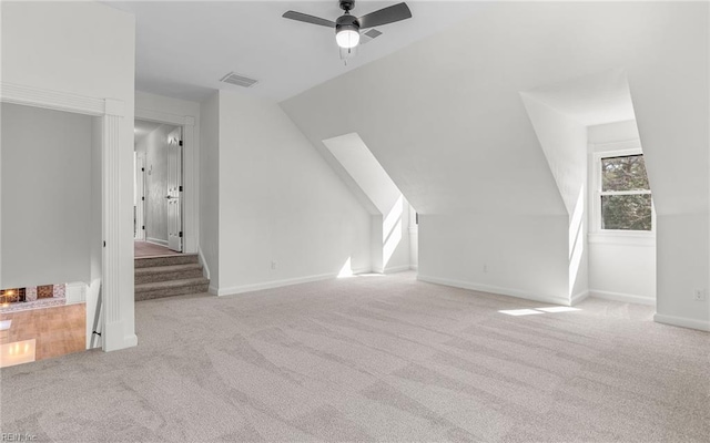 additional living space with carpet floors, visible vents, vaulted ceiling, ceiling fan, and baseboards