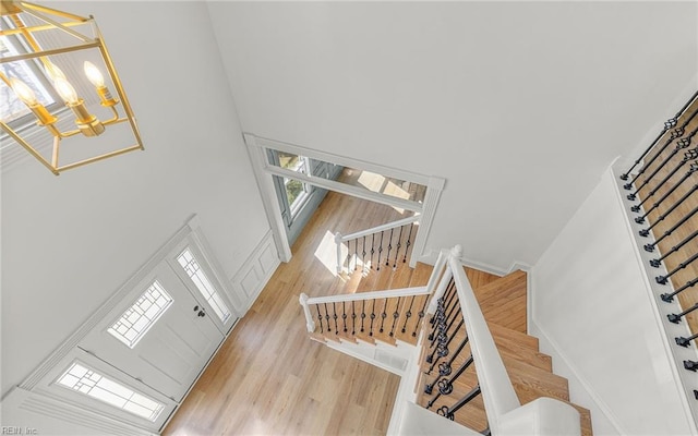 foyer entrance featuring a towering ceiling, baseboards, and wood finished floors