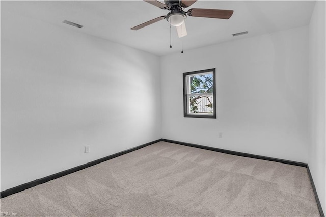 unfurnished room with carpet, visible vents, baseboards, and a ceiling fan