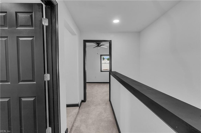 corridor featuring light carpet, baseboards, and recessed lighting