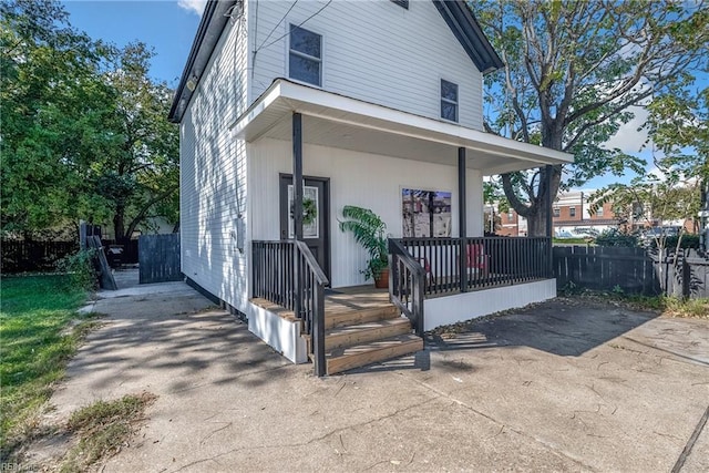 view of front of home with covered porch and fence