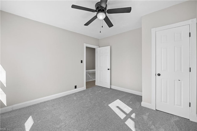 unfurnished bedroom featuring carpet floors, baseboards, and a ceiling fan