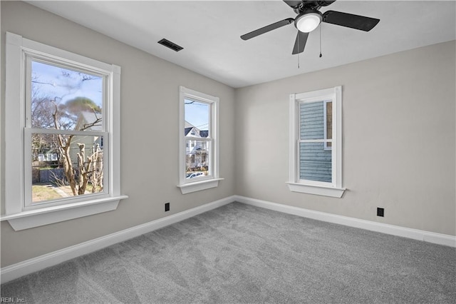 carpeted empty room with visible vents, ceiling fan, and baseboards