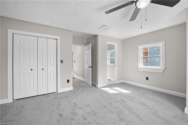 unfurnished bedroom with carpet floors, a closet, ceiling fan, and baseboards