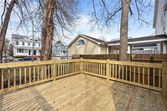 wooden terrace featuring a residential view and fence