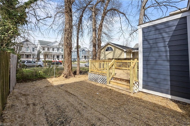 view of yard with a residential view, fence, and a wooden deck