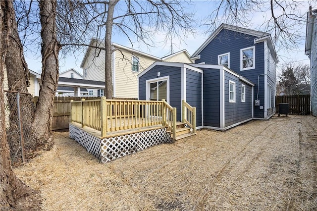 rear view of property featuring a deck, central AC unit, and a fenced backyard