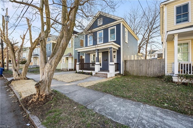 view of front of house featuring a porch, a residential view, and fence