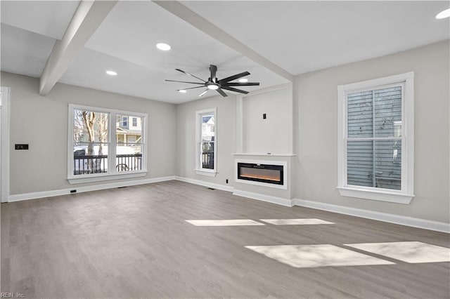 unfurnished living room with baseboards, a glass covered fireplace, ceiling fan, wood finished floors, and recessed lighting