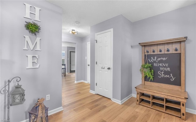 hallway with baseboards and light wood finished floors