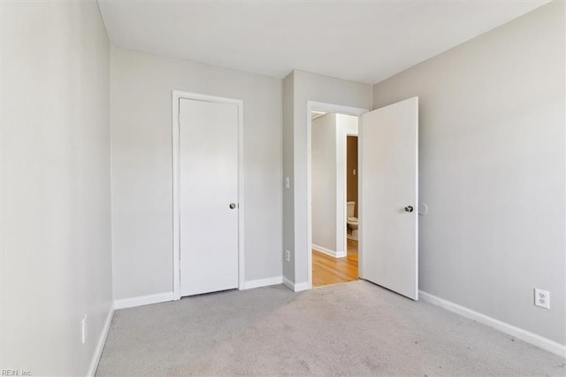 unfurnished bedroom featuring a closet, carpet flooring, and baseboards