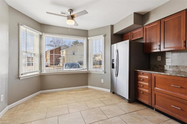 kitchen featuring ceiling fan, plenty of natural light, baseboards, and stainless steel fridge with ice dispenser