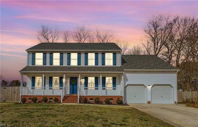 view of front of home featuring a porch, a lawn, an attached garage, fence, and driveway