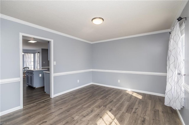 empty room with baseboards, dark wood finished floors, and ornamental molding