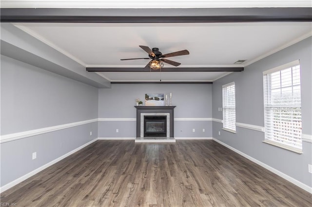 unfurnished living room featuring wood finished floors, visible vents, baseboards, a glass covered fireplace, and crown molding