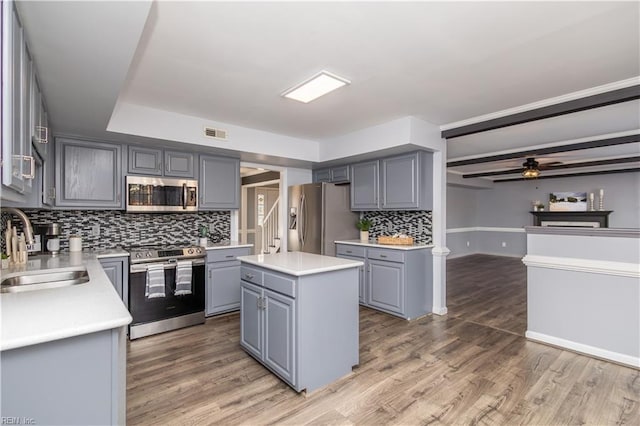 kitchen featuring a sink, visible vents, appliances with stainless steel finishes, gray cabinets, and light wood finished floors