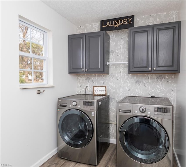 washroom with a textured ceiling, wood finished floors, cabinet space, and washer and dryer