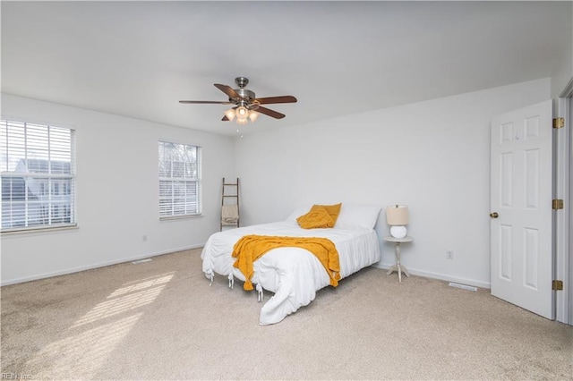 bedroom with light colored carpet, ceiling fan, and baseboards