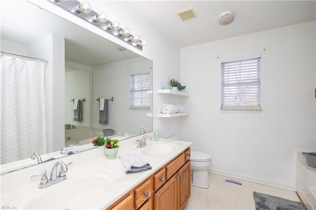 full bath featuring double vanity, visible vents, toilet, and a sink