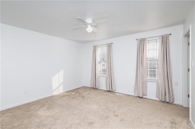 spare room featuring a ceiling fan, carpet flooring, visible vents, and baseboards