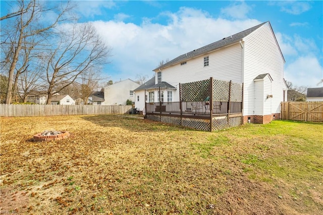 back of property featuring a wooden deck, a fire pit, a fenced backyard, crawl space, and a yard