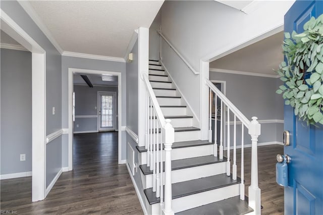 entryway with crown molding, baseboards, and wood finished floors