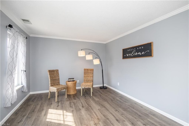 unfurnished room with visible vents, crown molding, baseboards, and wood finished floors