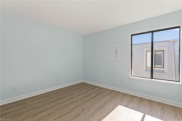 empty room with baseboards and wood finished floors