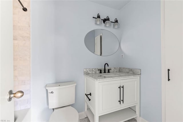 bathroom featuring toilet, baseboards, and vanity