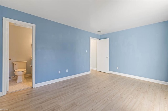 unfurnished bedroom with visible vents, light wood-style flooring, baseboards, and ensuite bathroom