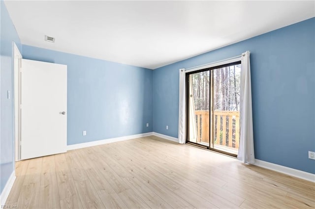 spare room featuring light wood-type flooring and baseboards