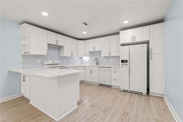 kitchen with white appliances, visible vents, white cabinets, a peninsula, and open shelves