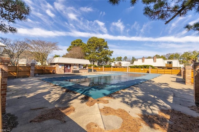 pool with a patio and fence