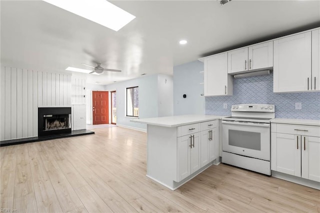 kitchen featuring light wood-style flooring, light countertops, white electric range, and a peninsula