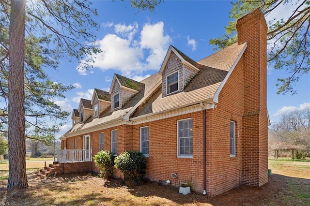 view of home's exterior featuring brick siding and a chimney