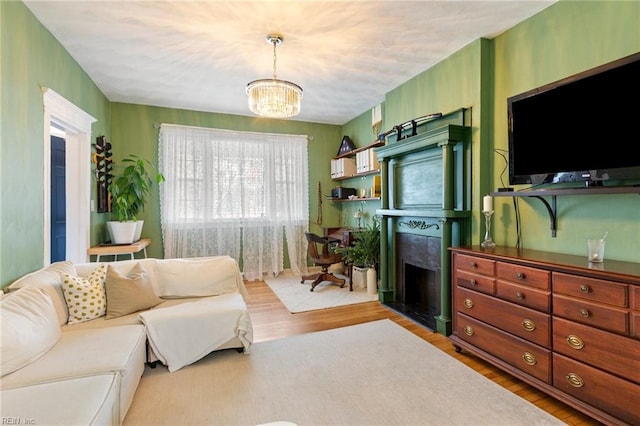 living room featuring a fireplace, a notable chandelier, and wood finished floors