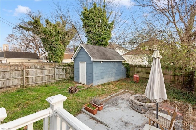 view of yard with an outbuilding, a shed, a patio area, and a fenced backyard