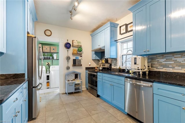 kitchen with light tile patterned floors, blue cabinets, appliances with stainless steel finishes, independent washer and dryer, and decorative backsplash