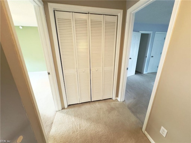 hallway with carpet floors and baseboards