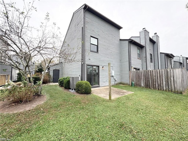 back of house with central AC, a lawn, a patio area, and fence