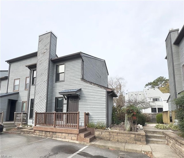 view of front of property featuring uncovered parking and a chimney