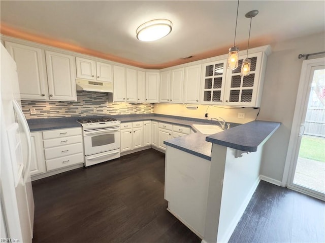 kitchen with white cabinets, a sink, a peninsula, white appliances, and under cabinet range hood