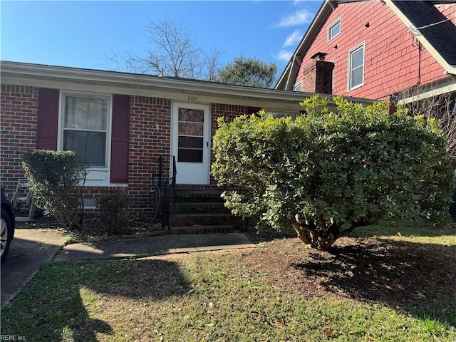 view of front of house featuring entry steps and brick siding