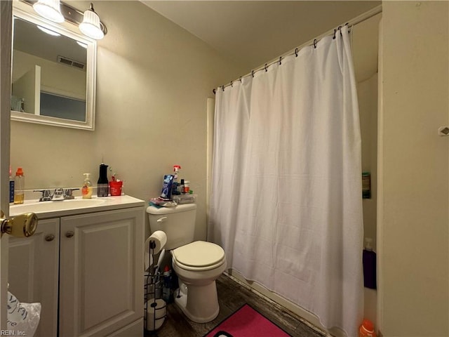 bathroom with toilet, curtained shower, and vanity