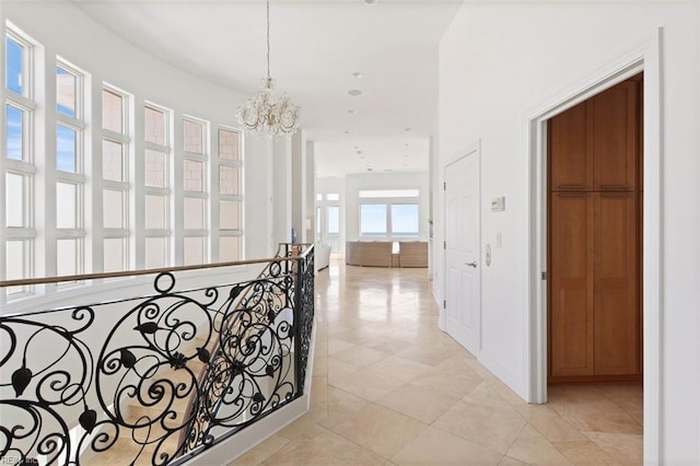 hall with an upstairs landing and a notable chandelier