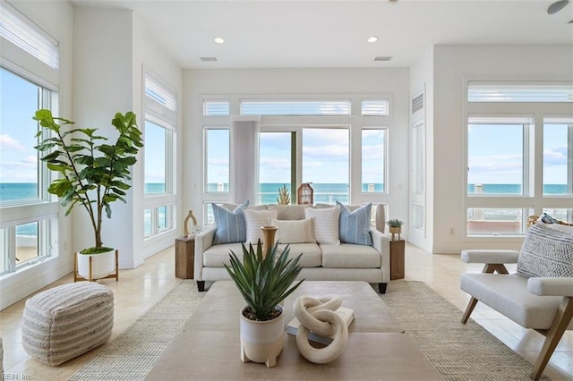 sunroom / solarium with a water view, visible vents, and a wealth of natural light